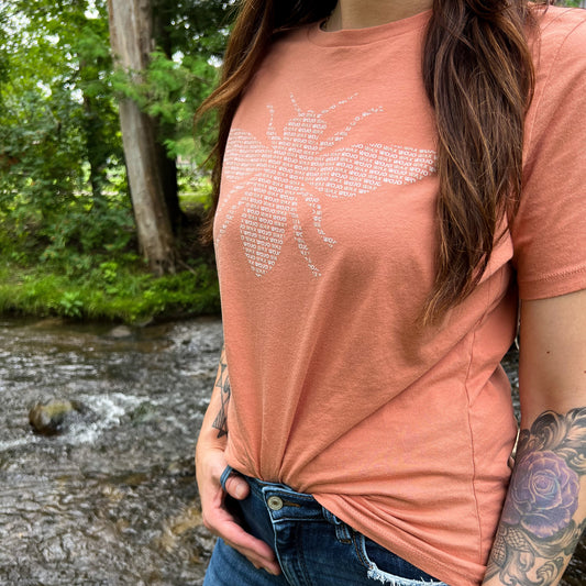 Peach Bee Tee on a female by a river